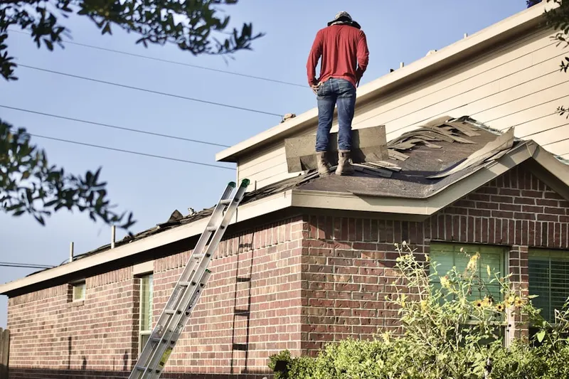 Professional roofer working on a residential roof in Wahneta